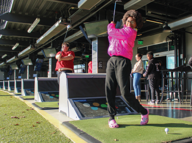 girl swinging golf club